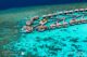vue sur les villas pilotis de W Maldives avec accès direct au snorkeling et récifs magnifiques. Les villas en haut de la photo sont les mieux placées.