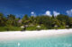 les villas sur la plage de W Maldives sont cachées dans la végétation, au bord d’une plage de sable blanc