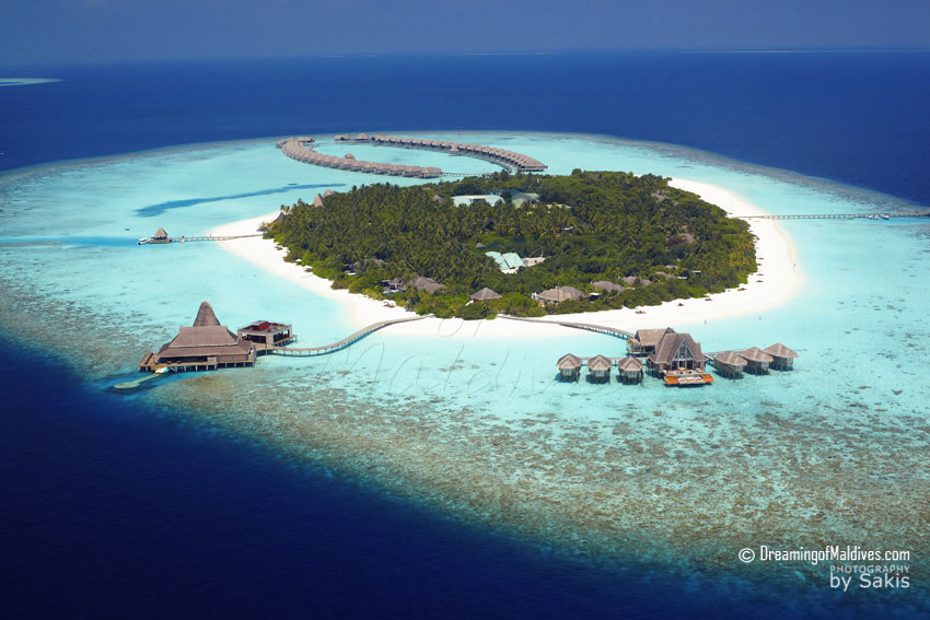 Anantara Kihavah Maldives Vue Aérienne de l'île, avec le Spa et les restaurants et bars sur pilotis en premier plan