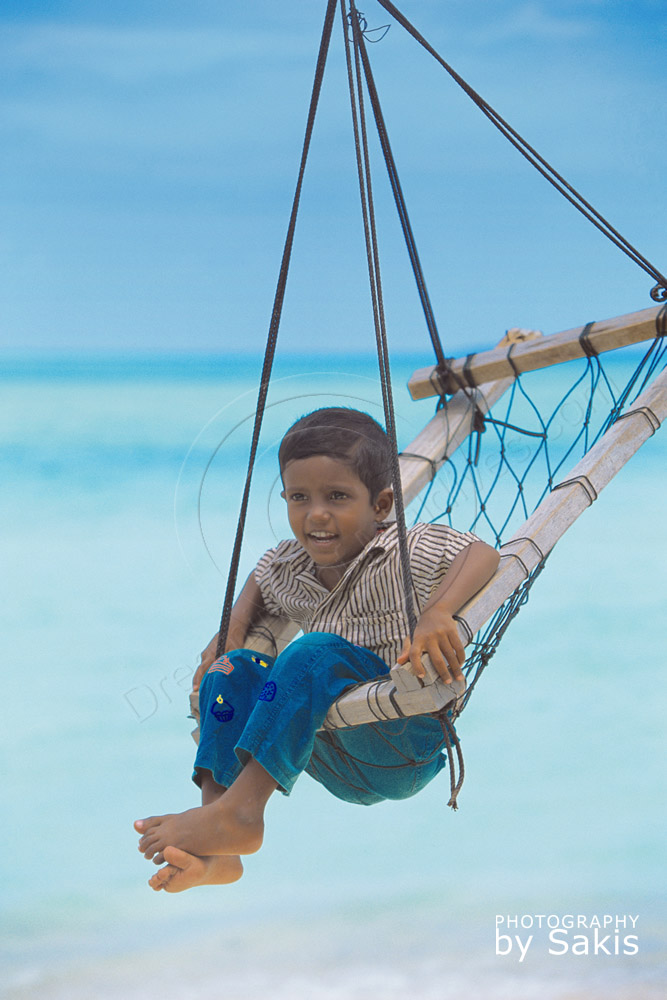 Enfant des Iles Maldives sur une balancelle traditionnelle