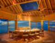 Soneva Fushi Maldives dine at a table with a roof that opens onto the stars