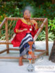 Young maldivian woman dressed with the Dhivehi Libaas smoking the shisha.