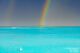 A beautiful rainbow cascading right onto an island. A magical moment of the rainy season in the Maldives