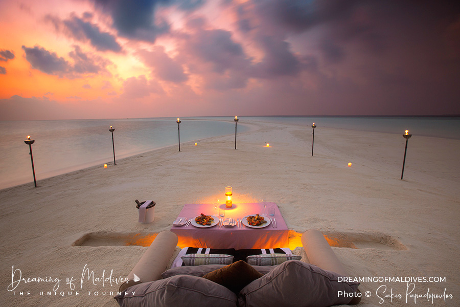 private romantic sunset beach dinner at a table dug in the sand at Milaidhoo sandbank