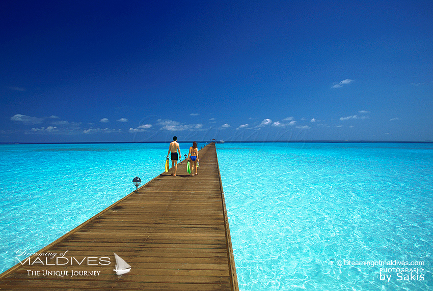 tourists walking on a jetty in Maldives
